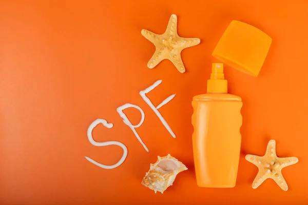 Sunscreen. Jar, cosmetic tube with SPF cream on a bright orange background. The concept of skin care and protection from ultraviolet rays. Photoaging. Choice of sunscreen.place for text.copy space.