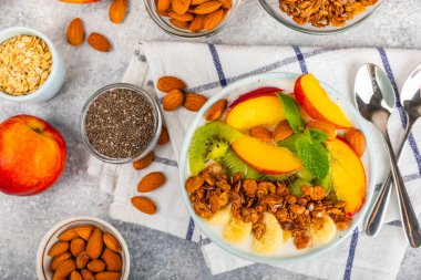 Bir kase granola yoğurt ve dokuma masasında taze böğürtlen. Yoğurt böğürtlen, acai kasesi, spirulina kasesi. Sağlıklı yemek, dengeli kahvaltı. Çilek, yabanmersini, kivi, şeftali, badem ve chia.. 