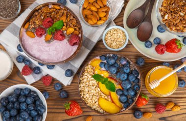 Bir kase granola yoğurt ve dokuma masasında taze böğürtlen. Yoğurt böğürtlen, acai kasesi, spirulina kasesi. Sağlıklı yemek, dengeli kahvaltı. Çilek, yabanmersini, kivi, şeftali, badem ve chia.. 