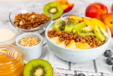 Bir kase granola yoğurt ve dokuma masasında taze böğürtlen. Yoğurt böğürtlen, acai kasesi, spirulina kasesi. Sağlıklı yemek, dengeli kahvaltı. Çilek, yabanmersini, kivi, şeftali, badem ve chia.. 