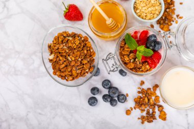 Bir kase granola yoğurt ve dokuma masasında taze böğürtlen. Yoğurt böğürtlen, acai kasesi, spirulina kasesi. Sağlıklı yemek, dengeli kahvaltı. Çilek, yabanmersini, kivi, şeftali, badem ve chia.. 