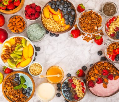 Bir kase granola yoğurt ve dokuma masasında taze böğürtlen. Yoğurt böğürtlen, acai kasesi, spirulina kasesi. Sağlıklı yemek, dengeli kahvaltı. Çilek, yabanmersini, kivi, şeftali, badem ve chia.. 