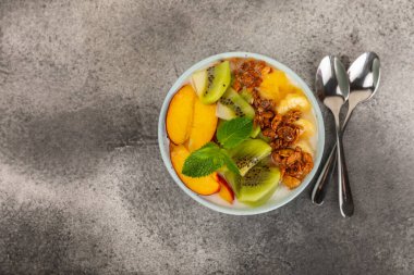 Bir kase granola yoğurt ve dokuma masasında taze böğürtlen. Yoğurt böğürtlen, acai kasesi, spirulina kasesi. Sağlıklı yemek, dengeli kahvaltı. Çilek, yabanmersini, kivi, şeftali, badem ve chia.. 