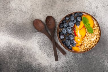 Bir kase granola yoğurt ve dokuma masasında taze böğürtlen. Yoğurt böğürtlen, acai kasesi, spirulina kasesi. Sağlıklı yemek, dengeli kahvaltı. Çilek, yabanmersini, kivi, şeftali, badem ve chia.. 