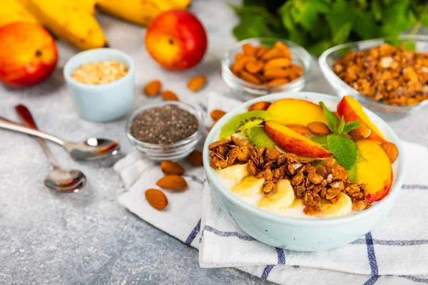 Bir kase granola yoğurt ve dokuma masasında taze böğürtlen. Yoğurt böğürtlen, acai kasesi, spirulina kasesi. Sağlıklı yemek, dengeli kahvaltı. Çilek, yabanmersini, kivi, şeftali, badem ve chia.. 