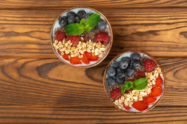 Bir kase granola yoğurt ve dokuma masasında taze böğürtlen. Yoğurt böğürtlen, acai kasesi, spirulina kasesi. Sağlıklı yemek, dengeli kahvaltı. Çilek, yabanmersini, kivi, şeftali, badem ve chia.. 