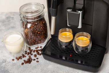 Mutfak masasında fincan olan modern kahve makinesi. Kahve evi. Mutfakta fincanı olan bir kahve makinesi. Sıcak kokulu bir içecek hazırlıyorum. Metin için yer. Boşluğu kopyala.