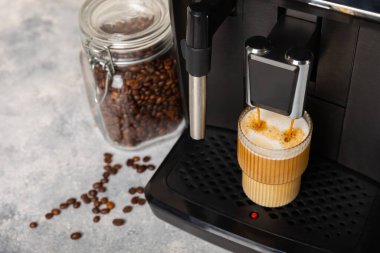 Mutfak masasında fincan olan modern kahve makinesi. Kahve evi. Mutfakta fincanı olan bir kahve makinesi. Sıcak kokulu bir içecek hazırlıyorum. Metin için yer. Boşluğu kopyala.