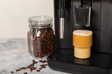 Mutfak masasında fincan olan modern kahve makinesi. Kahve evi. Mutfakta fincanı olan bir kahve makinesi. Sıcak kokulu bir içecek hazırlıyorum. Metin için yer. Boşluğu kopyala.