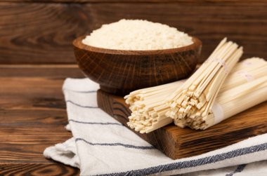 Funchoza. Kurutulmuş çiğ pirinç eriştesi ve pirinçli pilav. Pirinç unlu erişte. Diyet yemek. Sağlıklı yiyecekler. Mesaj için yer. Kopyalamak için yer.