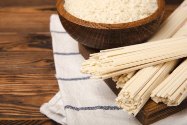 Funchoza. Kurutulmuş çiğ pirinç eriştesi ve pirinçli pilav. Pirinç unlu erişte. Diyet yemek. Sağlıklı yiyecekler. Mesaj için yer. Kopyalamak için yer.