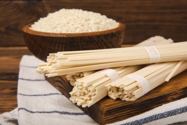 Funchoza. Kurutulmuş çiğ pirinç eriştesi ve pirinçli pilav. Pirinç unlu erişte. Diyet yemek. Sağlıklı yiyecekler. Mesaj için yer. Kopyalamak için yer.