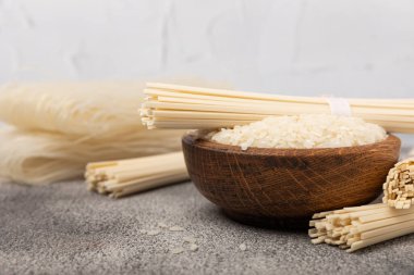 Funchoza. Kurutulmuş çiğ pirinç eriştesi ve pirinçli pilav. Pirinç unlu erişte. Diyet yemek. Sağlıklı yiyecekler. Mesaj için yer. Kopyalamak için yer.