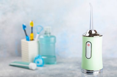 Elektronik ağız temizleyici, diş fırçası, macun, diş ipi ve ağız gargarası. Ağız hijyeni için diş aleti. Elektrikli İnterdental Temizleyici. Diş suyu banyosu. Oral bakım kavramı.