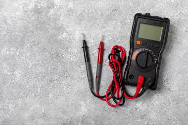 Mermer zemin üzerinde mermer arkaplanlı elektrikli ekipman. Üst görünüm. Elektrikli alet seti. Çoklu metre, testçi, tornavida, kesiciler, koli bandı, lamba, mezura, mezura ve kablo. İnşaat konsepti.