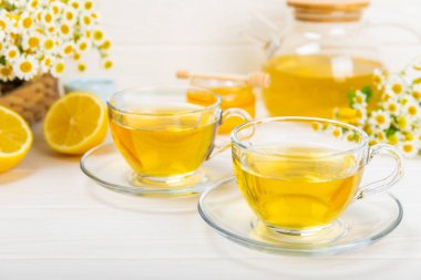 Arka planda taze papatya çiçekleri olan bitki çayı. Sakinleştirici ve rahatlatıcı bir içecek. Dokunulmazlık. Bir fincan sıcak papatya çayı. Çay içme konsepti. Çay seremonisi. Metin için yer, kopyalama alanı.