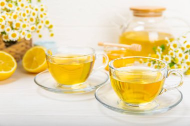 Arka planda taze papatya çiçekleri olan bitki çayı. Sakinleştirici ve rahatlatıcı bir içecek. Dokunulmazlık. Bir fincan sıcak papatya çayı. Çay içme konsepti. Çay seremonisi. Metin için yer, kopyalama alanı.