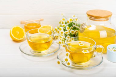 Arka planda taze papatya çiçekleri olan bitki çayı. Sakinleştirici ve rahatlatıcı bir içecek. Dokunulmazlık. Bir fincan sıcak papatya çayı. Çay içme konsepti. Çay seremonisi. Metin için yer, kopyalama alanı.