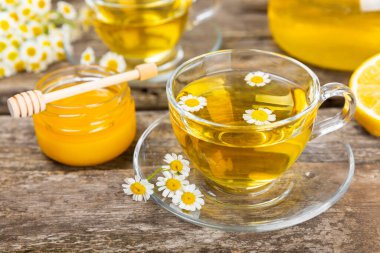 Arka planda taze papatya çiçekleri olan bitki çayı. Sakinleştirici ve rahatlatıcı bir içecek. Dokunulmazlık. Bir fincan sıcak papatya çayı. Çay içme konsepti. Çay seremonisi. Metin için yer, kopyalama alanı.