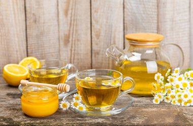 Arka planda taze papatya çiçekleri olan bitki çayı. Sakinleştirici ve rahatlatıcı bir içecek. Dokunulmazlık. Bir fincan sıcak papatya çayı. Çay içme konsepti. Çay seremonisi. Metin için yer, kopyalama alanı.