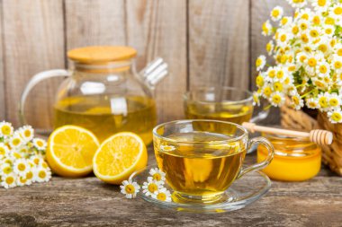 Arka planda taze papatya çiçekleri olan bitki çayı. Sakinleştirici ve rahatlatıcı bir içecek. Dokunulmazlık. Bir fincan sıcak papatya çayı. Çay içme konsepti. Çay seremonisi. Metin için yer, kopyalama alanı.