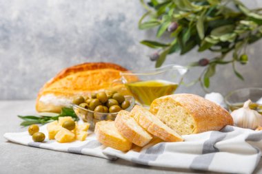 Ciabatta ve zeytin. Otlu taze İtalyan ciabatta ekmeği, zeytinyağı, parmesan ve pesto sosu, ahşap arka planda zeytin, üst manzara, kopyalama alanı. Mesaj için yer. Boşluğu kopyala.