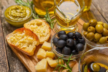 Ciabatta ve zeytin. Otlu taze İtalyan ciabatta ekmeği, zeytinyağı, parmesan ve pesto sosu, ahşap arka planda zeytin, üst manzara, kopyalama alanı. Mesaj için yer. Boşluğu kopyala.
