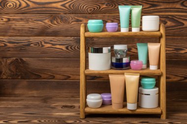 Sağlıklı cilt bakımı aşamasında- yüz serumu ve losyon, ovalama, soyma ve temizleme beyaz ahşap arka planda. Güzellik ve kozmetik konsepti. Ahşap bir rafta bir takım kozmetik ürünler. 