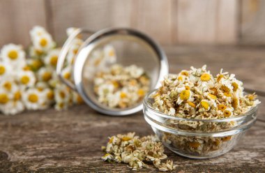 Tahta bir masanın üzerinde papatya çiçekleri. Rahatlatıcı papatya çayı. Bitkisel içecek. Düz plan. Ders için alan. Kopya alanı. Tıbbi önleme ve bağışıklık konsepti. Halk alternatif tıbbı.