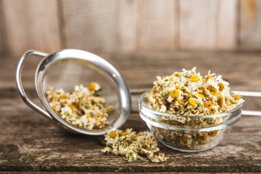 Tahta bir masanın üzerinde papatya çiçekleri. Rahatlatıcı papatya çayı. Bitkisel içecek. Düz plan. Ders için alan. Kopya alanı. Tıbbi önleme ve bağışıklık konsepti. Halk alternatif tıbbı.