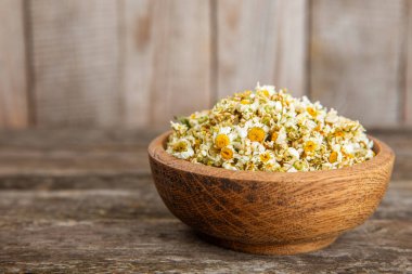 Tahta bir masanın üzerinde papatya çiçekleri. Rahatlatıcı papatya çayı. Bitkisel içecek. Düz plan. Ders için alan. Kopya alanı. Tıbbi önleme ve bağışıklık konsepti. Halk alternatif tıbbı.