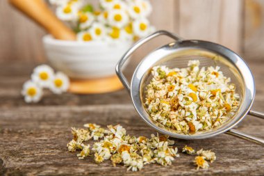 Tahta bir masanın üzerinde papatya çiçekleri. Rahatlatıcı papatya çayı. Bitkisel içecek. Düz plan. Ders için alan. Kopya alanı. Tıbbi önleme ve bağışıklık konsepti. Halk alternatif tıbbı.