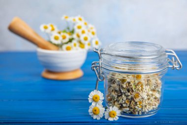 Tahta bir masanın üzerinde papatya çiçekleri. Rahatlatıcı papatya çayı. Bitkisel içecek. Düz plan. Ders için alan. Kopya alanı. Tıbbi önleme ve bağışıklık konsepti. Halk alternatif tıbbı.