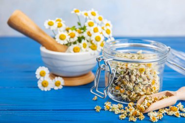 Tahta bir masanın üzerinde papatya çiçekleri. Rahatlatıcı papatya çayı. Bitkisel içecek. Düz plan. Ders için alan. Kopya alanı. Tıbbi önleme ve bağışıklık konsepti. Halk alternatif tıbbı.