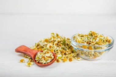 Tahta bir masanın üzerinde papatya çiçekleri. Rahatlatıcı papatya çayı. Bitkisel içecek. Düz plan. Ders için alan. Kopya alanı. Tıbbi önleme ve bağışıklık konsepti. Halk alternatif tıbbı.