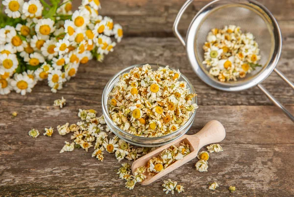 Tahta bir masanın üzerinde papatya çiçekleri. Rahatlatıcı papatya çayı. Bitkisel içecek. Düz plan. Ders için alan. Kopya alanı. Tıbbi önleme ve bağışıklık konsepti. Halk alternatif tıbbı.