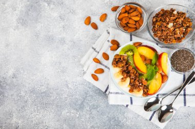 Bir kase granola yoğurt ve dokuma masasında taze böğürtlen. Yoğurt böğürtlen, acai kasesi, spirulina kasesi. Sağlıklı yemek, dengeli kahvaltı. Çilek, yabanmersini, kivi, şeftali, badem ve chia..