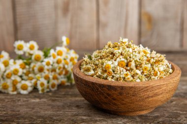 Tahta bir masanın üzerinde papatya çiçekleri. Rahatlatıcı papatya çayı. Bitkisel içecek. Düz plan. Ders için alan. Kopya alanı. Tıbbi önleme ve bağışıklık konsepti. Halk alternatif tıbbı.