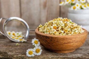 Tahta bir masanın üzerinde papatya çiçekleri. Rahatlatıcı papatya çayı. Bitkisel içecek. Düz plan. Ders için alan. Kopya alanı. Tıbbi önleme ve bağışıklık konsepti. Halk alternatif tıbbı.