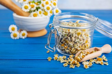 Tahta bir masanın üzerinde papatya çiçekleri. Rahatlatıcı papatya çayı. Bitkisel içecek. Düz plan. Ders için alan. Kopya alanı. Tıbbi önleme ve bağışıklık konsepti. Halk alternatif tıbbı.