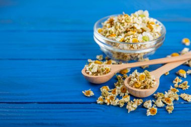 Tahta bir masanın üzerinde papatya çiçekleri. Rahatlatıcı papatya çayı. Bitkisel içecek. Düz plan. Ders için alan. Kopya alanı. Tıbbi önleme ve bağışıklık konsepti. Halk alternatif tıbbı.