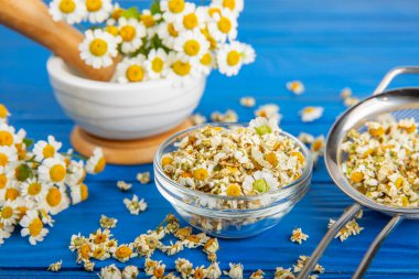 Tahta bir masanın üzerinde papatya çiçekleri. Rahatlatıcı papatya çayı. Bitkisel içecek. Düz plan. Ders için alan. Kopya alanı. Tıbbi önleme ve bağışıklık konsepti. Halk alternatif tıbbı.