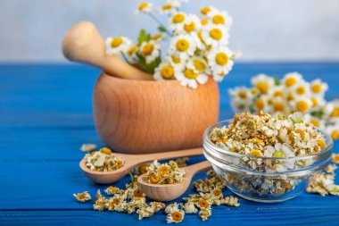 Tahta bir masanın üzerinde papatya çiçekleri. Rahatlatıcı papatya çayı. Bitkisel içecek. Düz plan. Ders için alan. Kopya alanı. Tıbbi önleme ve bağışıklık konsepti. Halk alternatif tıbbı.