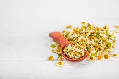 Tahta bir masanın üzerinde papatya çiçekleri. Rahatlatıcı papatya çayı. Bitkisel içecek. Düz plan. Ders için alan. Kopya alanı. Tıbbi önleme ve bağışıklık konsepti. Halk alternatif tıbbı.