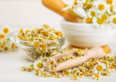 Tahta bir masanın üzerinde papatya çiçekleri. Rahatlatıcı papatya çayı. Bitkisel içecek. Düz plan. Ders için alan. Kopya alanı. Tıbbi önleme ve bağışıklık konsepti. Halk alternatif tıbbı.