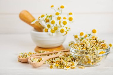 Tahta bir masanın üzerinde papatya çiçekleri. Rahatlatıcı papatya çayı. Bitkisel içecek. Düz plan. Ders için alan. Kopya alanı. Tıbbi önleme ve bağışıklık konsepti. Halk alternatif tıbbı.