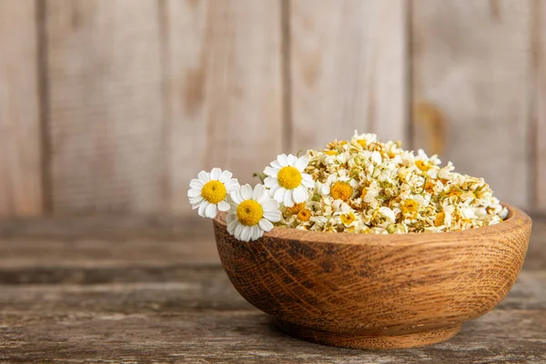 Tahta bir masanın üzerinde papatya çiçekleri. Rahatlatıcı papatya çayı. Bitkisel içecek. Düz plan. Ders için alan. Kopya alanı. Tıbbi önleme ve bağışıklık konsepti. Halk alternatif tıbbı.