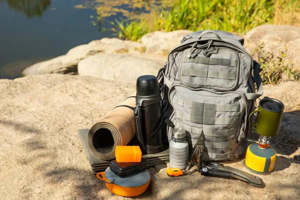 Backpack, thermos, gas burner, sleeping mat, knife, compass and tourist utensils in the mountains. Tourist equipment. place for text. Travel and hipster concept.Camping.Vacation. summer holidays.