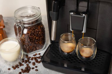 Mutfak masasında fincan olan modern kahve makinesi. Kahve evi. Mutfakta fincanı olan bir kahve makinesi. Sıcak kokulu bir içecek hazırlıyorum. Metin için yer. Boşluğu kopyala.