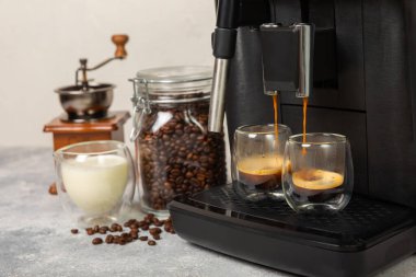 Mutfak masasında fincan olan modern kahve makinesi. Kahve evi. Mutfakta fincanı olan bir kahve makinesi. Sıcak kokulu bir içecek hazırlıyorum. Metin için yer. Boşluğu kopyala.